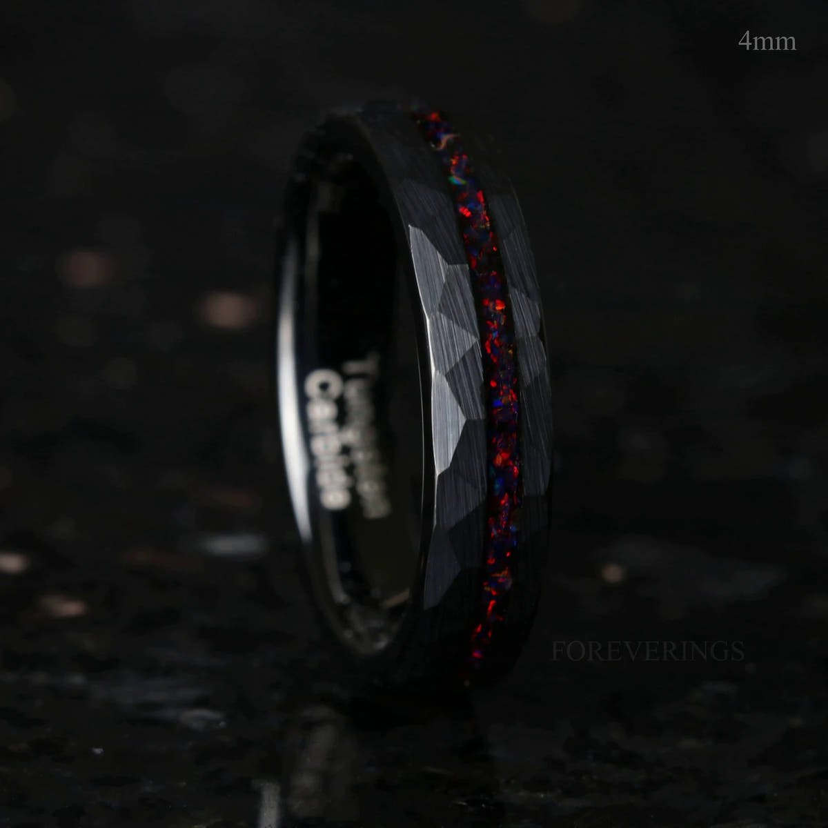 Women's 4mm black hammered tungsten ring with black fire opal inlay, standing on edge