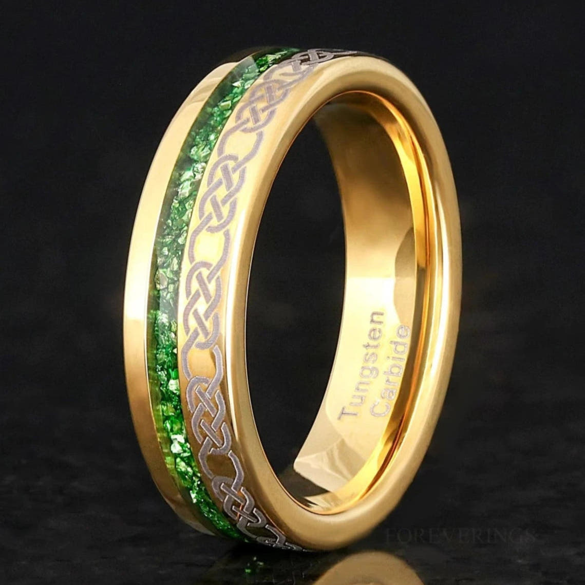 Men's 6mm gold tungsten wedding band with emerald inlay and a Celtic knot stripe, standing on edge