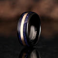 Men's 8mm black tungsten band with blue sandstone inlay and a rose gold center stripe, standing upright