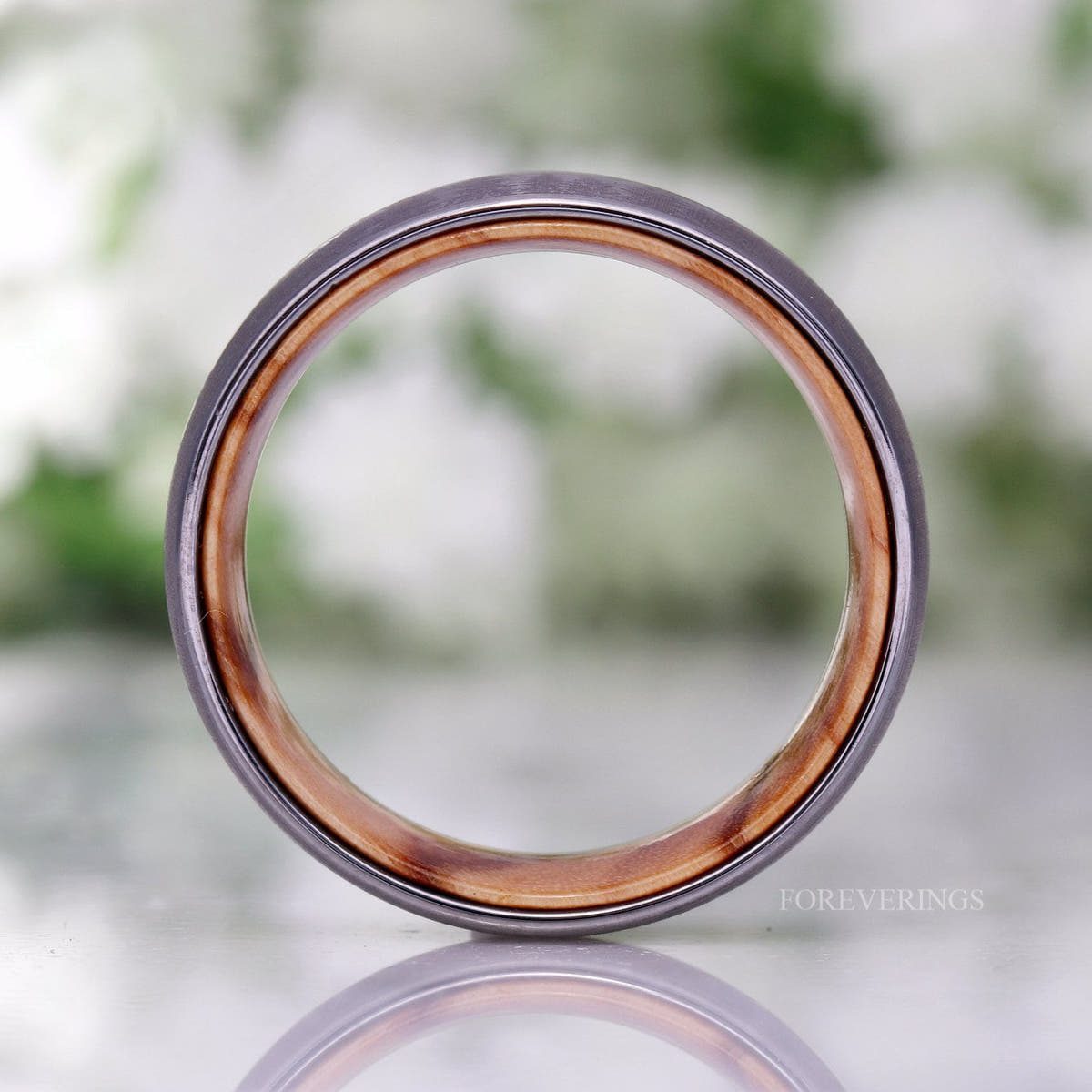 Silver tungsten band standing face-on, showing the full olive wood lining