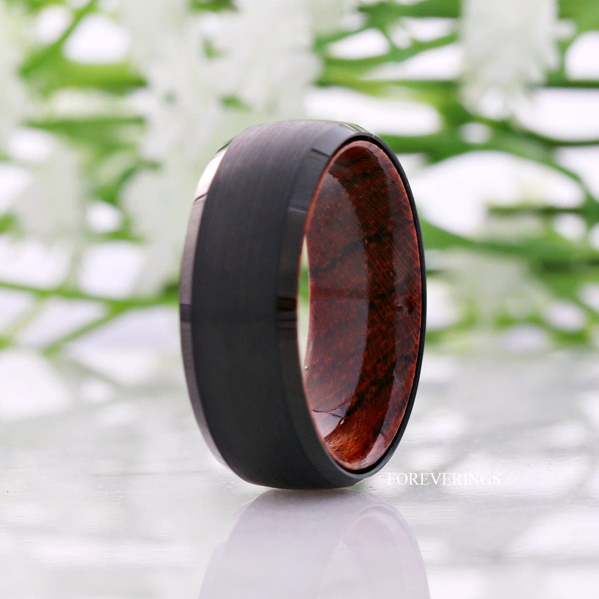 8mm black tungsten rosewood-lined band standing at an angle, wider view with reflection