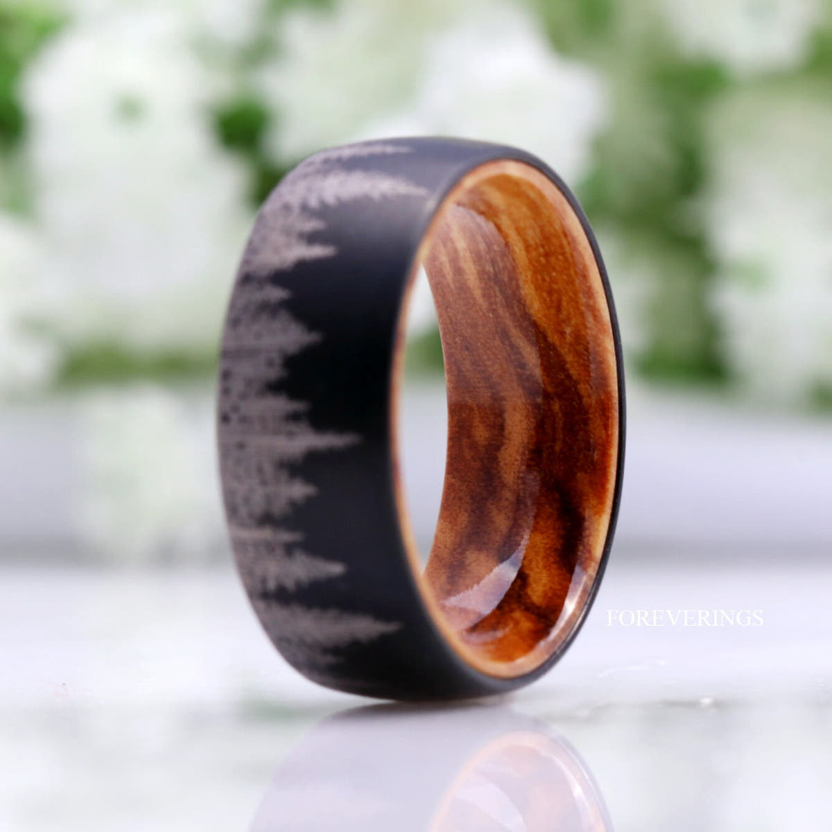 Black tungsten forest band with olive wood lining, standing at an angle