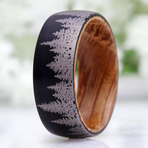 Men's 8mm black tungsten band with a pine forest design and whiskey barrel wood lining