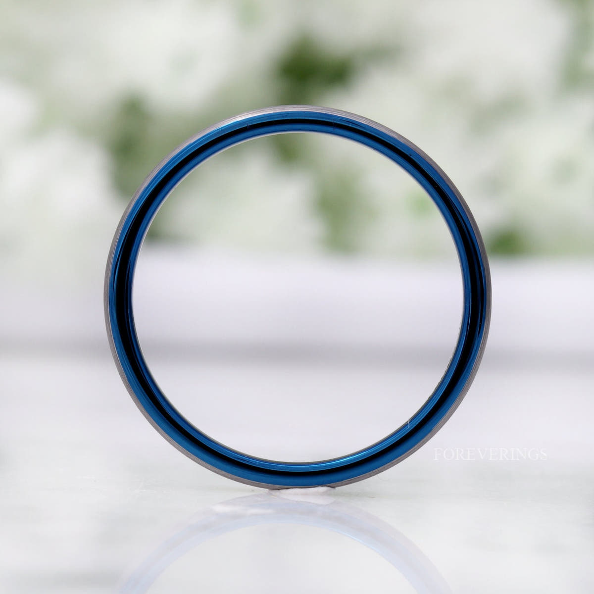 2mm tungsten band standing upright, viewed through the center to show the blue inside