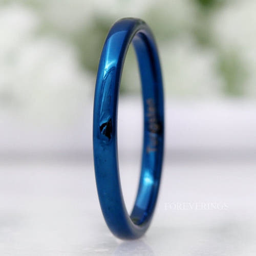 Minimalist 2mm blue tungsten wedding band standing on edge, polished dome in a close crop