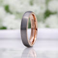 Women's 4mm matte silver tungsten band with a rose gold interior, standing at an angle
