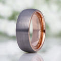 Men's 8mm matte silver tungsten dome band with a rose gold interior, standing at an angle