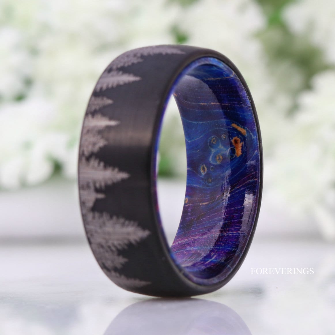 Black tungsten forest band angled to show the blue and purple wood interior
