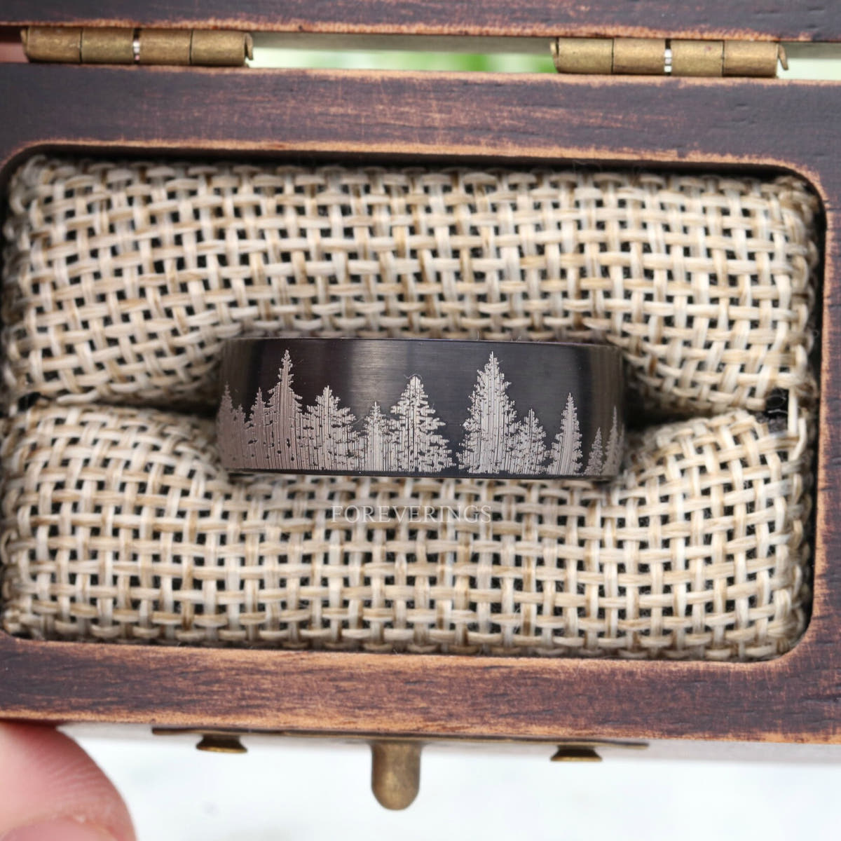 Black tungsten pine forest band in a rustic wood ring box with burlap insert