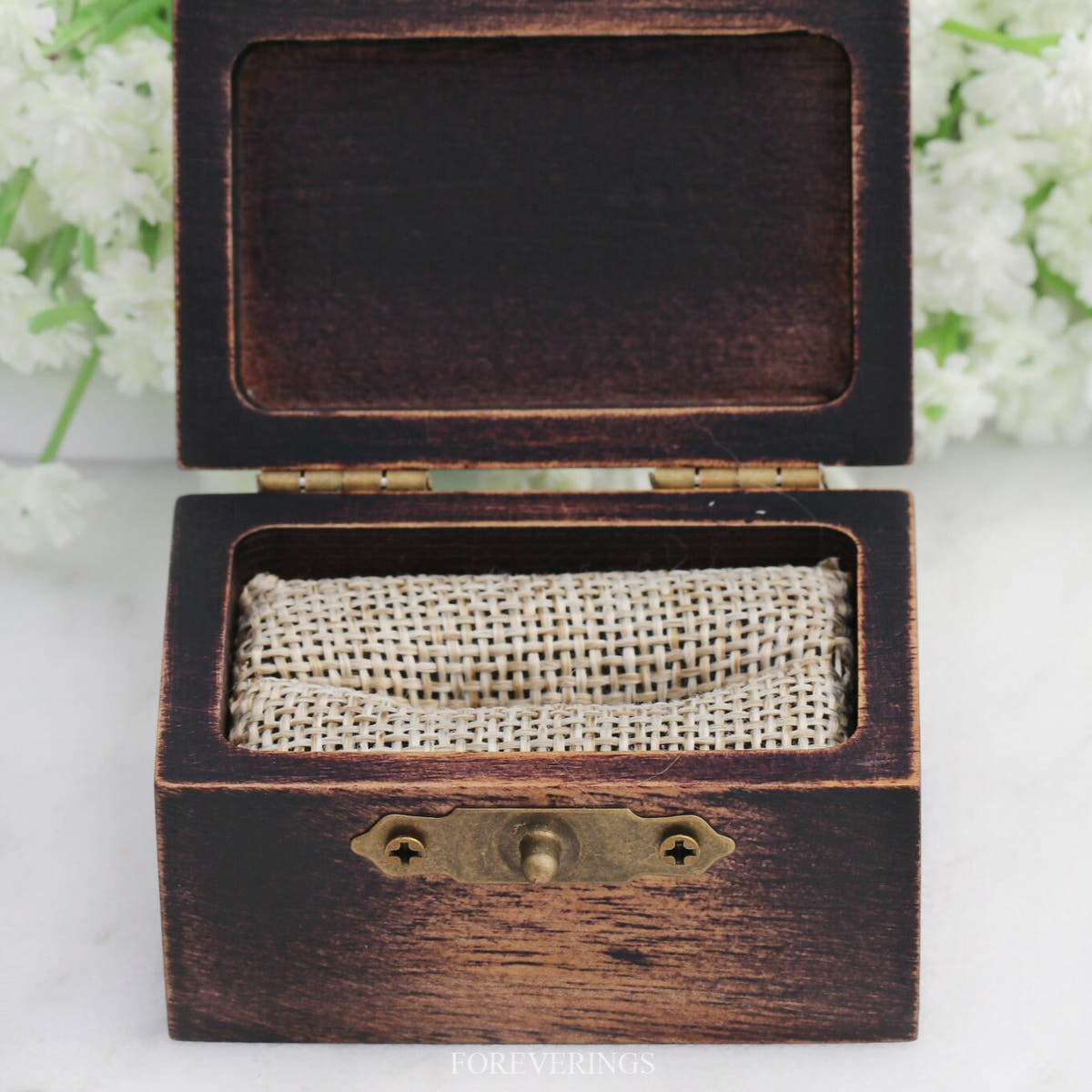 Empty wood ring box opened to show the burlap foam insert and lid