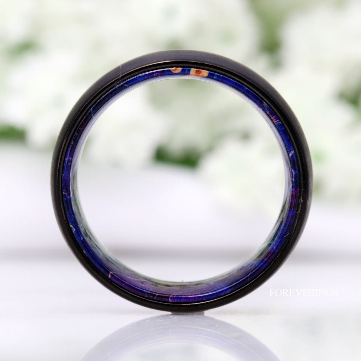 Black tungsten wood band seen straight through the center, blue elder wood lining all around