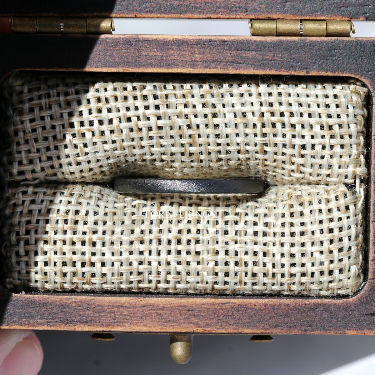 Close-up of the burlap foam insert gripping a band inside the wood box