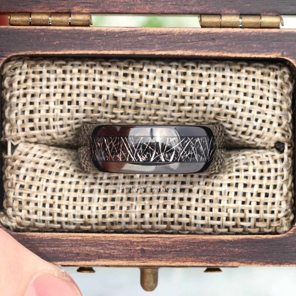 8mm black tungsten band with meteorite-look inlay in a rustic wood ring box