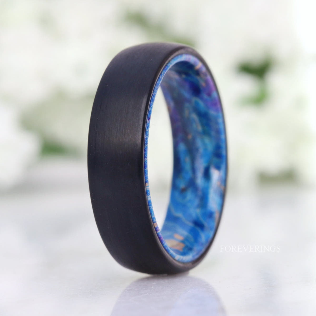 6mm brushed black tungsten band with a light blue elder wood lining, standing at an angle