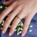 Women's 2mm silver tungsten band with rose gold interior worn on a hand
