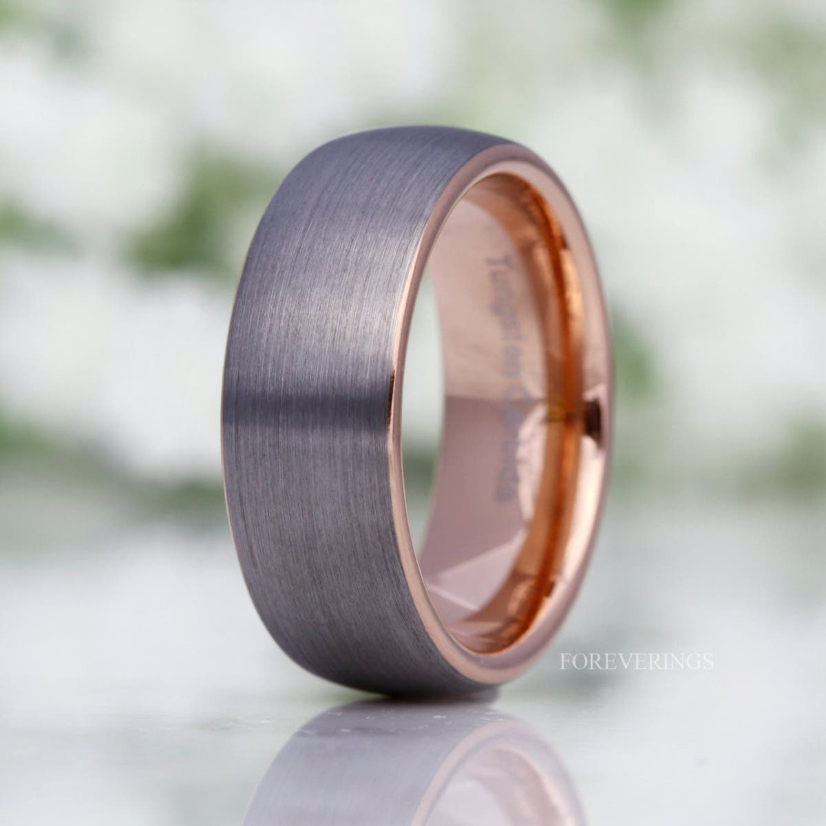 His 8mm brushed silver tungsten band with rose gold interior, domed and standing at an angle
