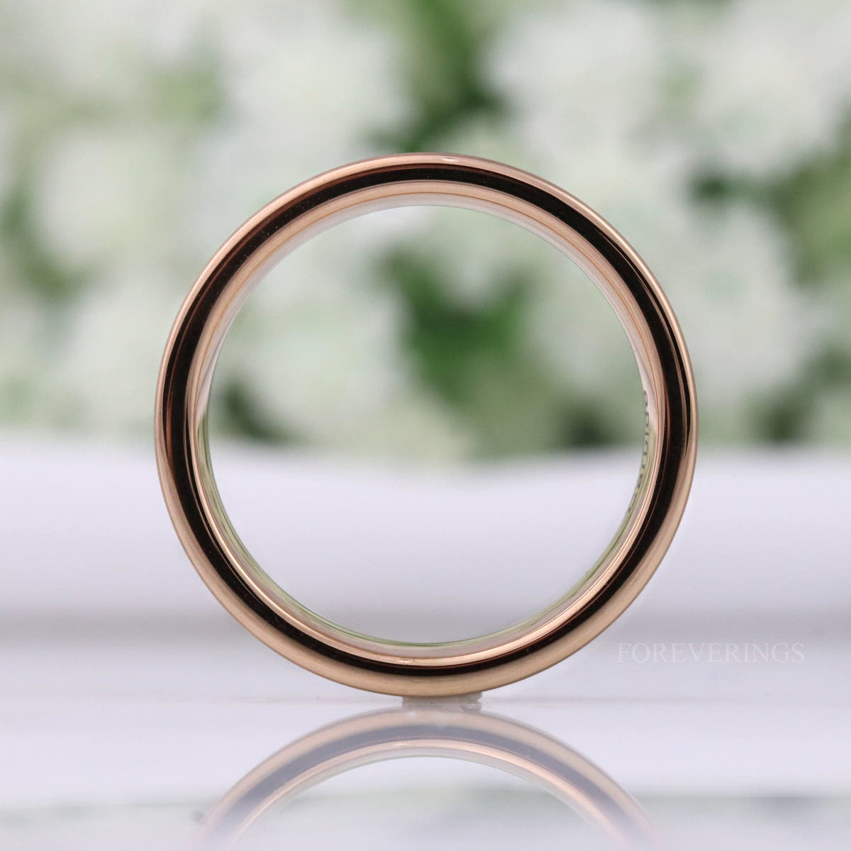 6mm rose gold tungsten band standing upright, viewed straight through the center