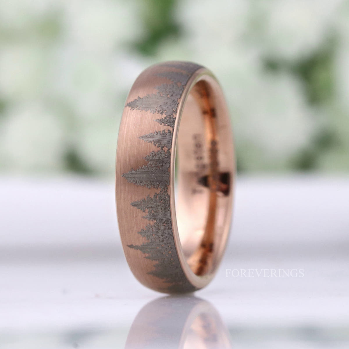 Rose gold tungsten band turned to show the gray pine silhouettes wrapping the side