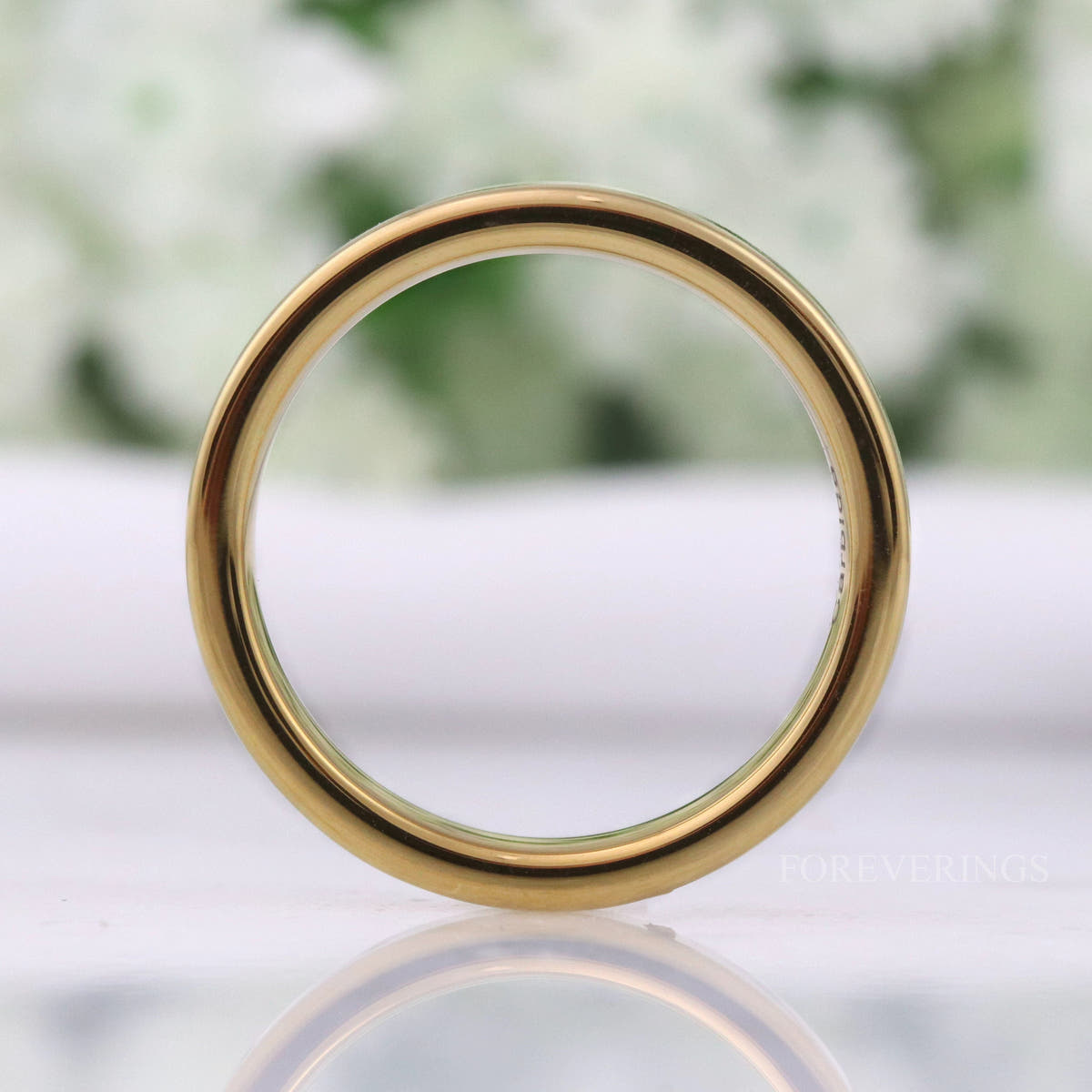 Flat gold tungsten band standing upright, seen head-on as a circle