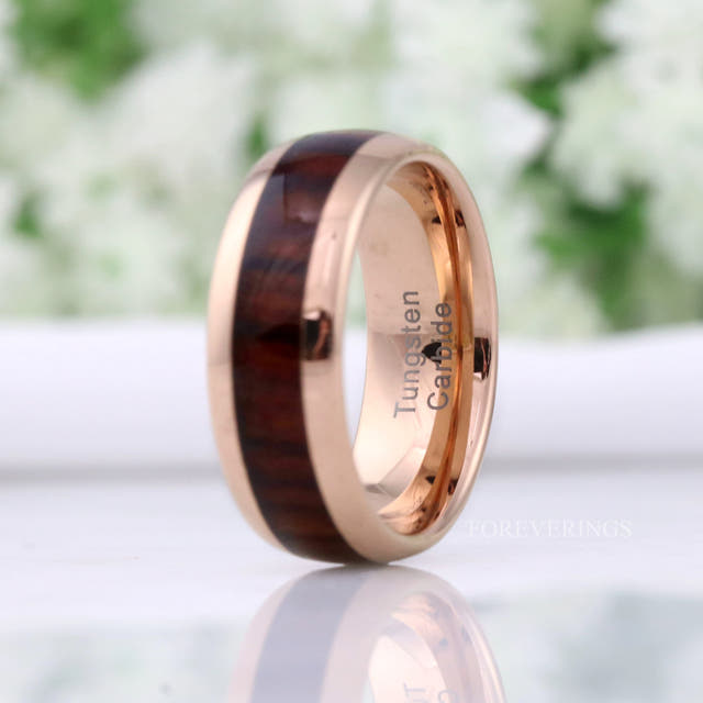 Rose gold tungsten koa wood band turned to show the polished rose gold interior