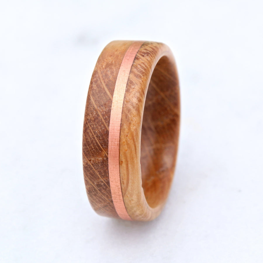 Whiskey barrel wood band with copper inlay on a plain white background