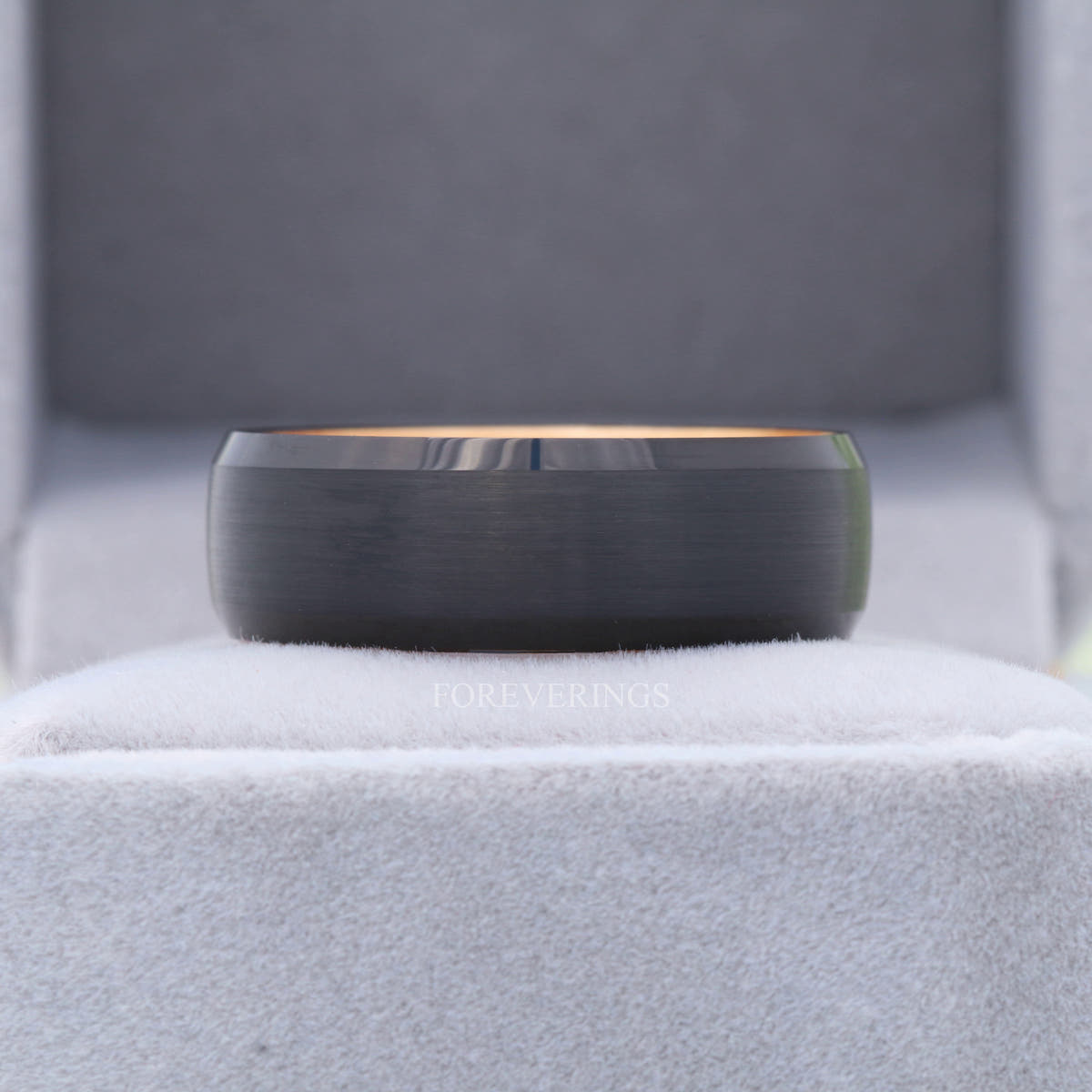 8mm black tungsten olive wood band standing in a gray ring box, front view