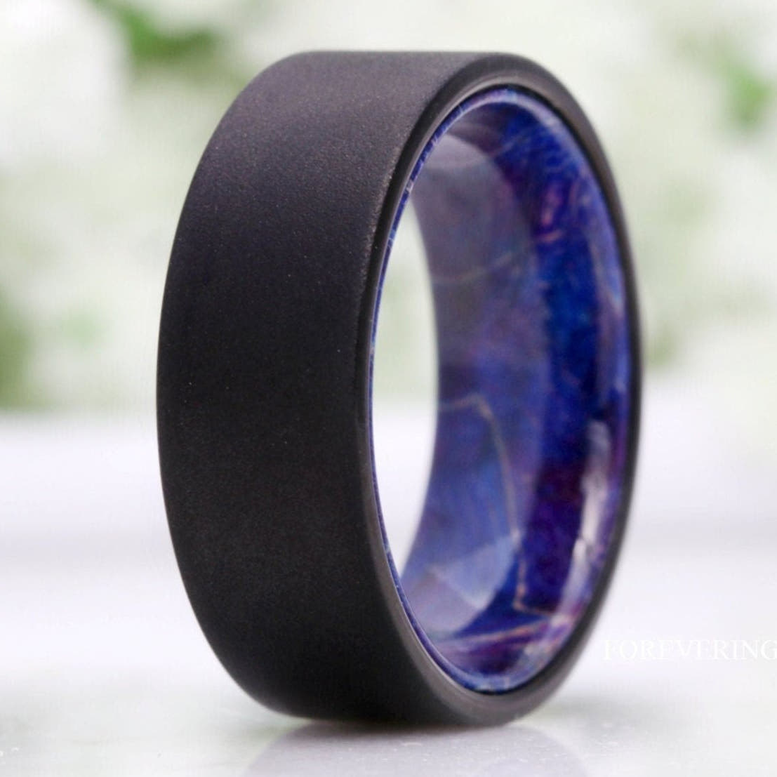 Men's 8mm sandblasted black tungsten band with blue elder wood interior, close crop