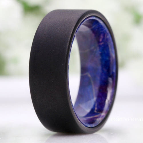 Men's 8mm sandblasted black tungsten band with blue elder wood interior, close crop