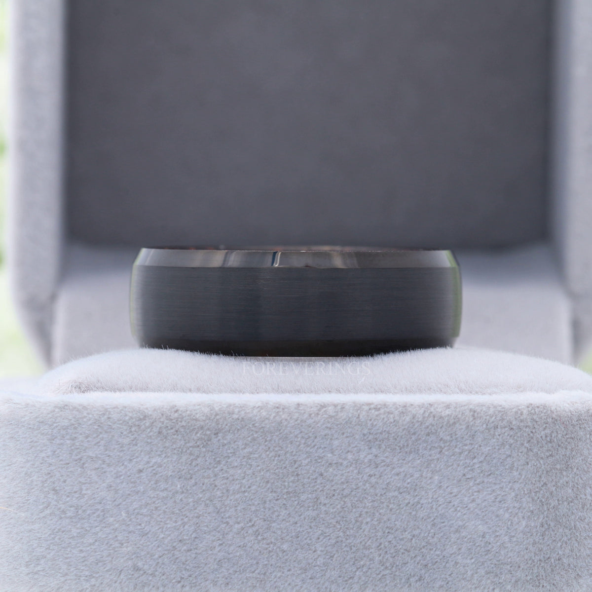 8mm black tungsten wenge wood band in a gray velvet ring box