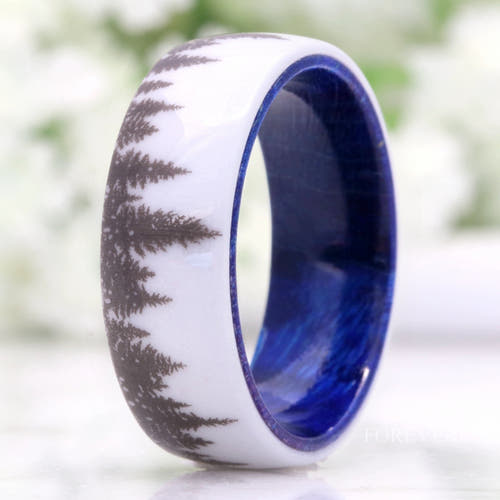 Men's white ceramic wedding band with a forest tree-line design and blue elder wood interior