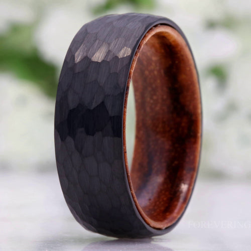 Men's 8mm hammered black tungsten wedding band with a zebra wood sleeve inside