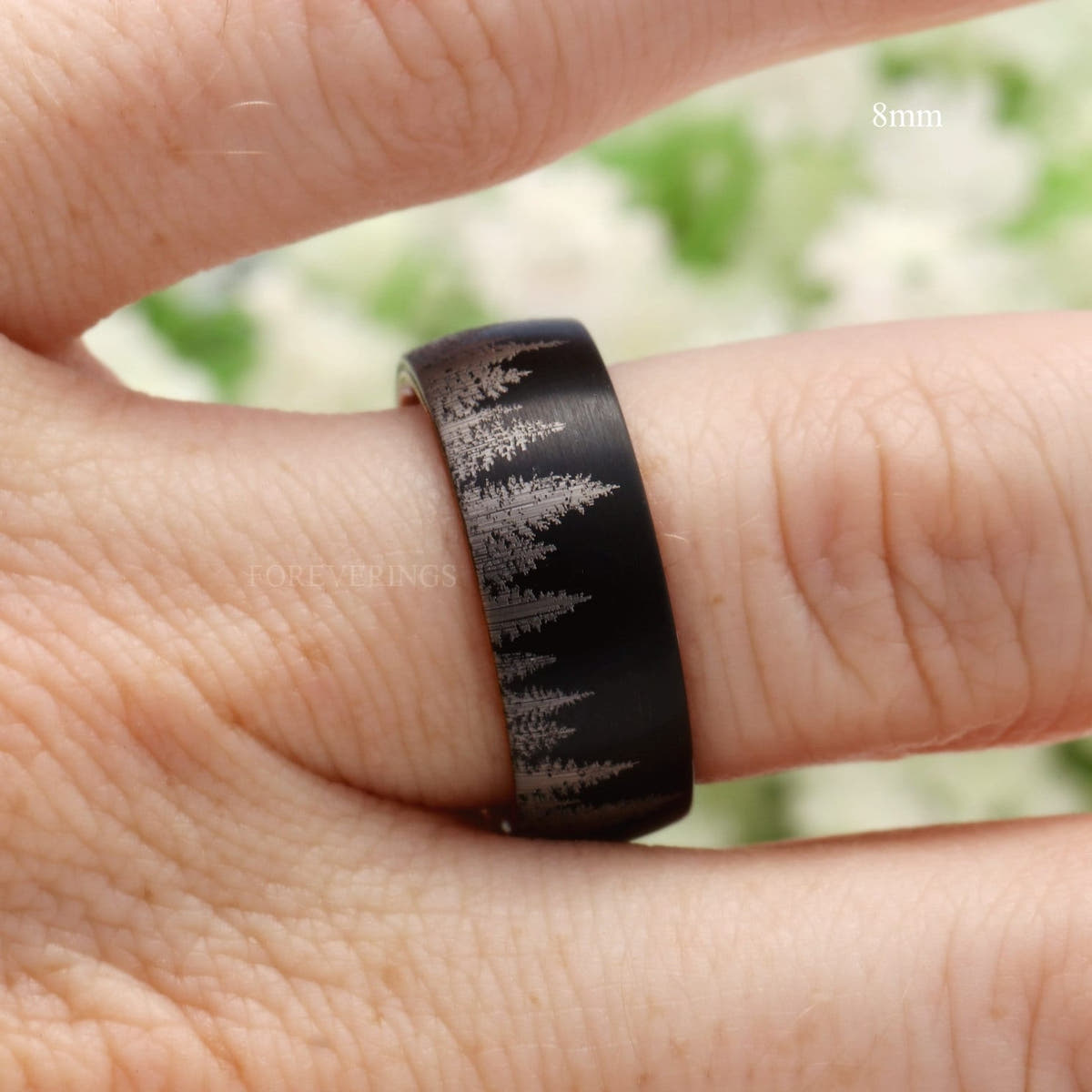 8mm black tungsten pine tree band worn on a finger