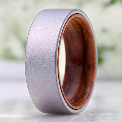Men's 8mm sandblasted silver tungsten wedding band with a zebra wood sleeve inside