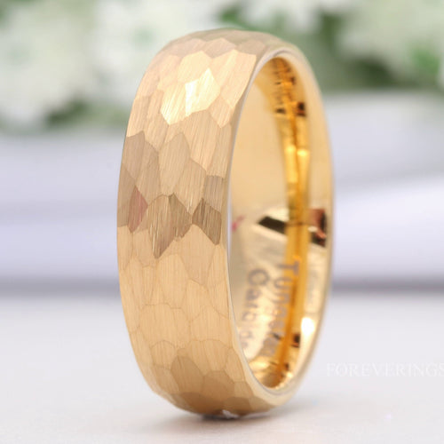 Men's 7mm hammered gold tungsten wedding band with a matte finish, standing on edge
