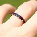 Women's 4mm silver tungsten ring with black fire opal inlay, worn on a hand
