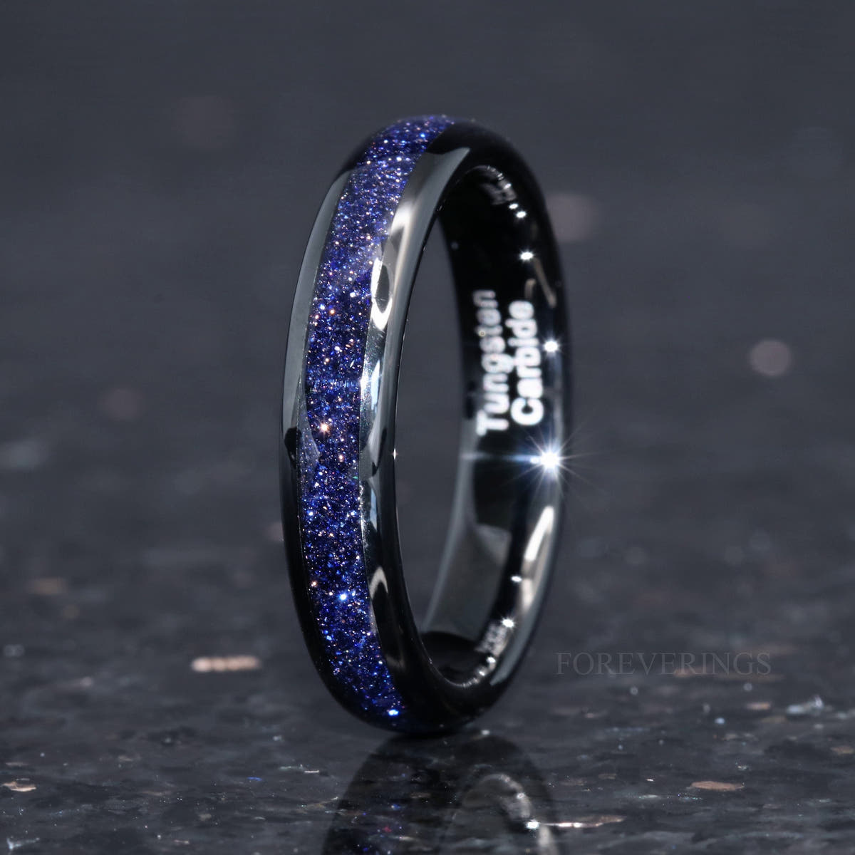 Women's 4mm black tungsten ring with blue sandstone inlay, angled to show the interior