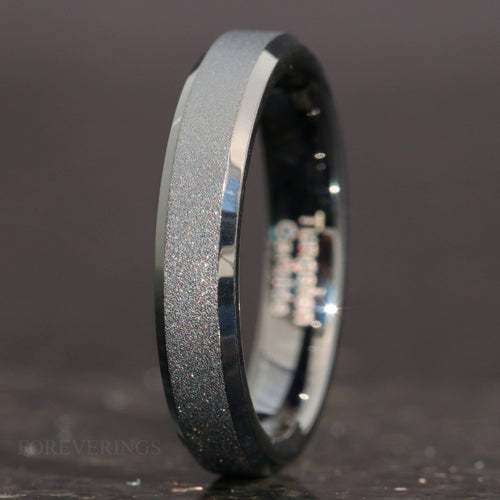 4mm sandblasted black tungsten wedding band with beveled edges, standing at an angle
