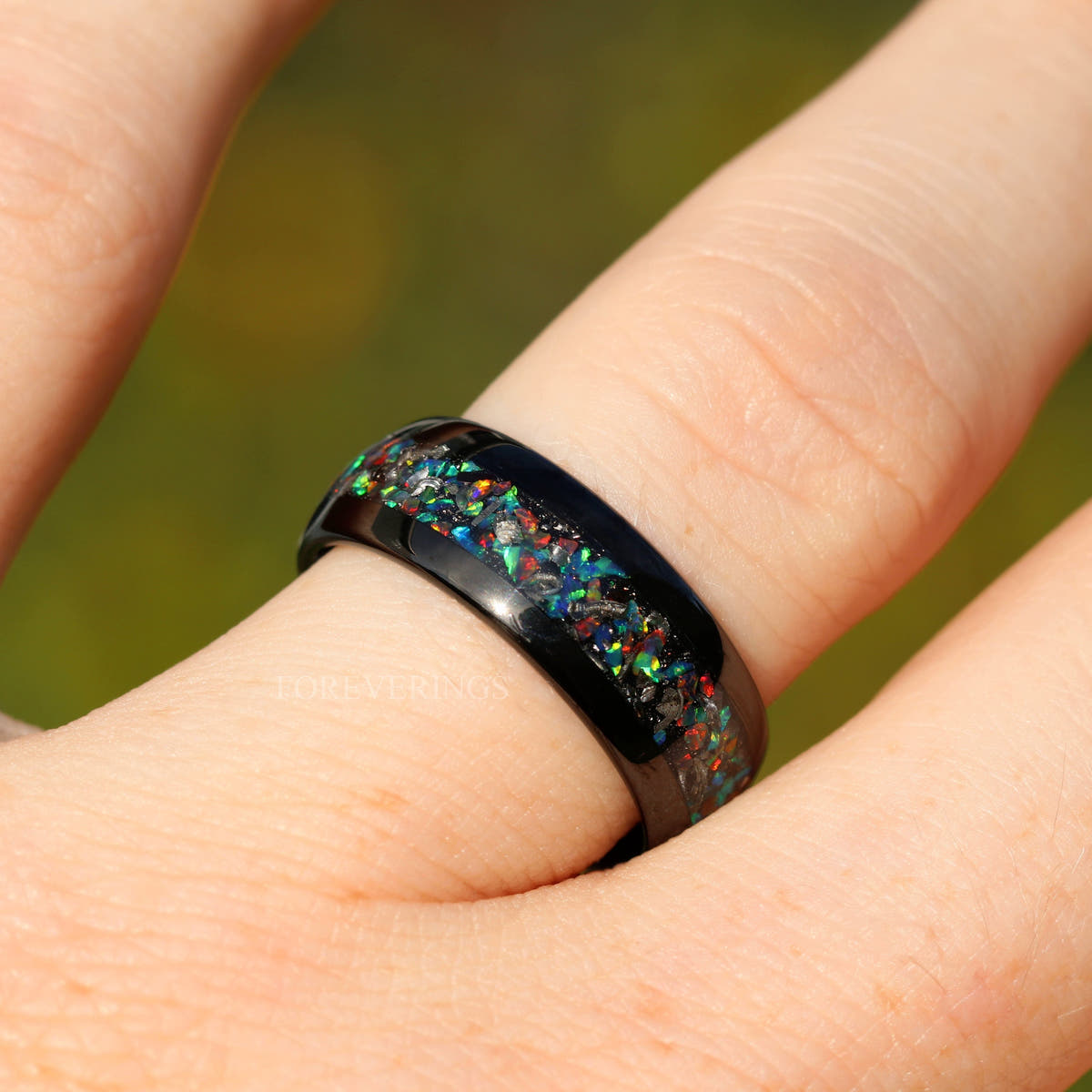 Men's 8mm black tungsten band with meteorite and galaxy opal inlay, worn on a hand