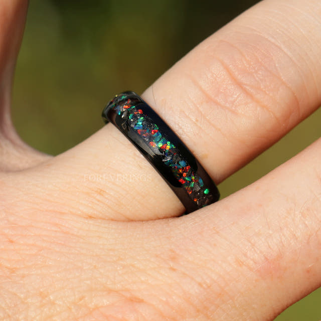 Black tungsten ring with meteorite and galaxy opal inlay worn on a finger