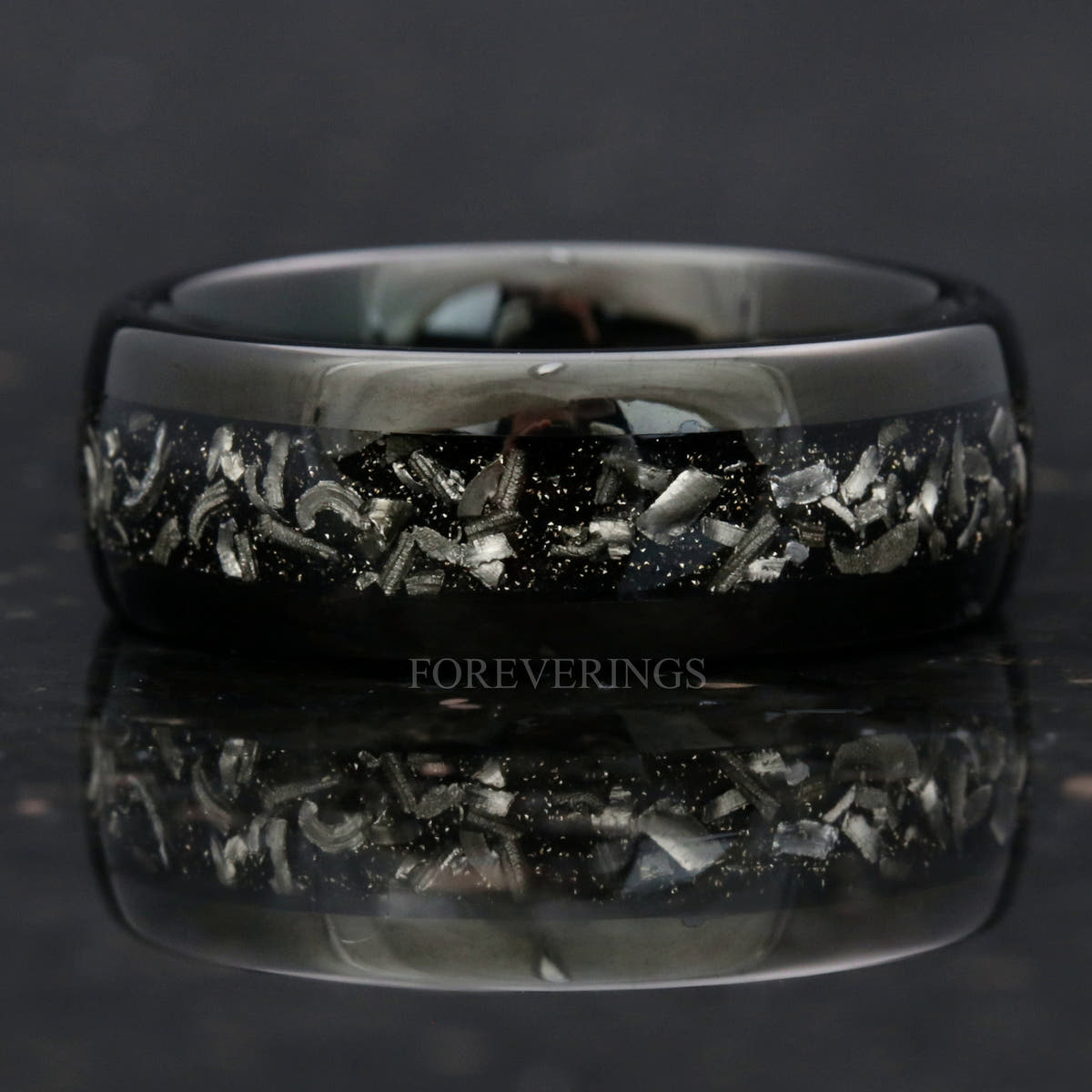 Black tungsten meteorite band shown straight on, silver meteorite fragments across the face