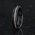 Women's 4mm hammered black tungsten ring with a crushed white fire opal stripe, angled