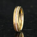 Women's 4mm hammered gold tungsten ring with a crushed white fire opal stripe, angled