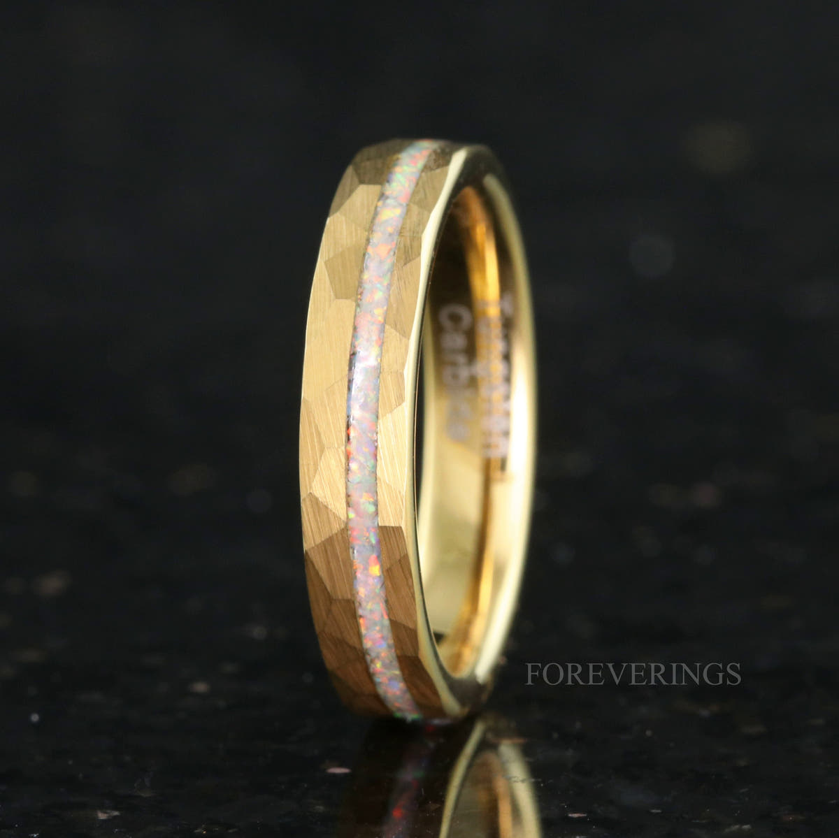Women's 4mm hammered gold tungsten ring with a crushed white fire opal stripe, angled