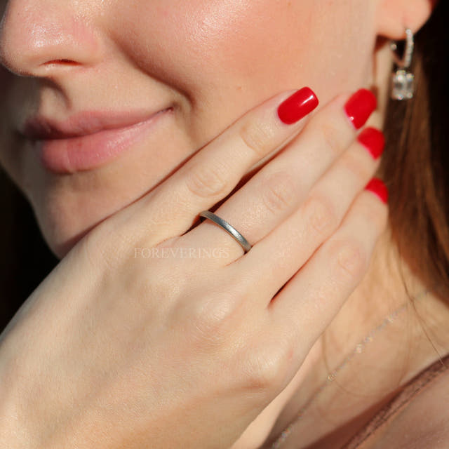Thin 2mm sandblasted silver tungsten band worn on a woman's hand
