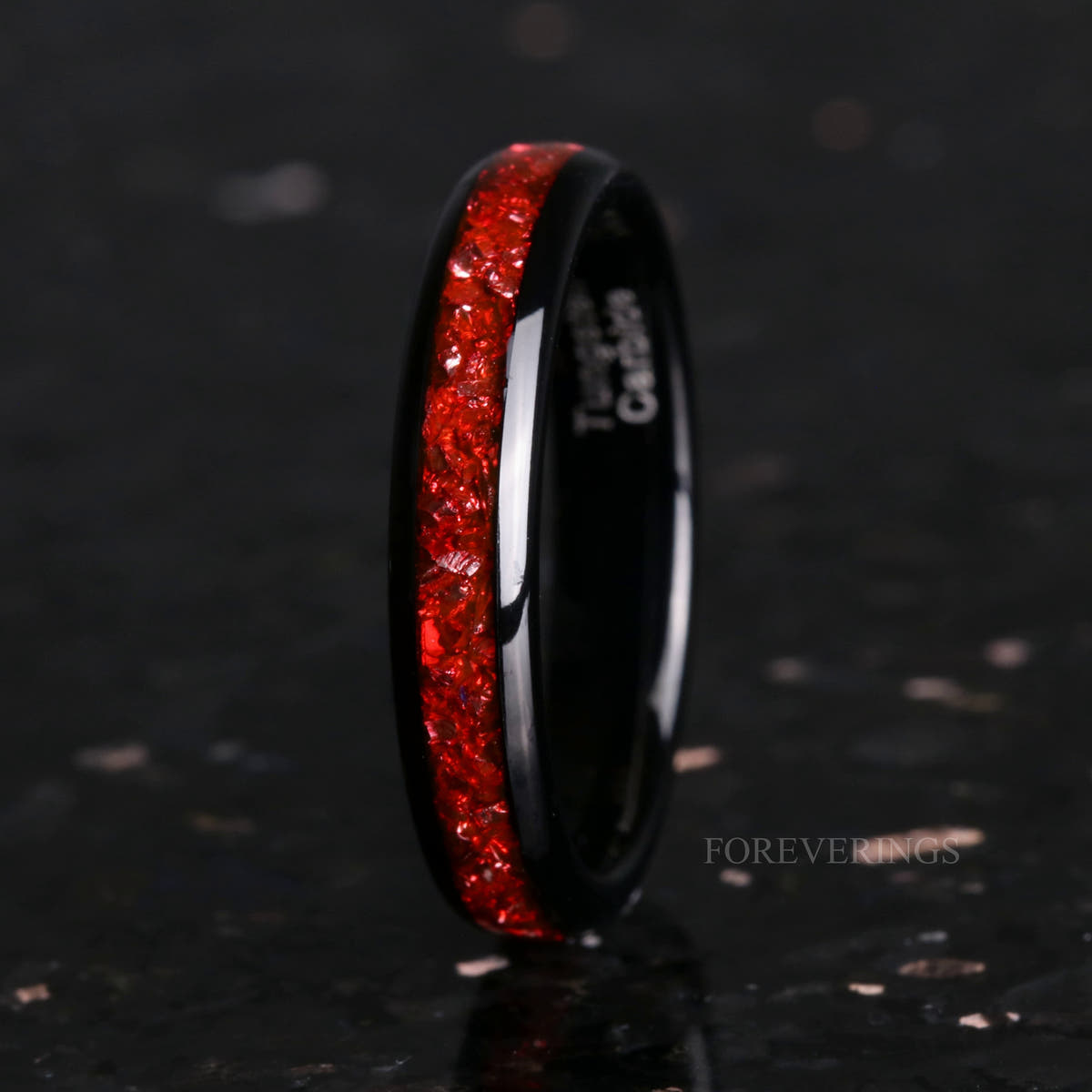 Women's 4mm black tungsten band with crushed ruby inlay, standing upright