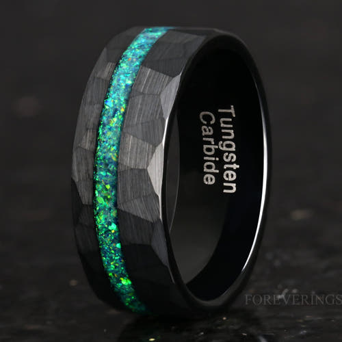Men's 8mm hammered black tungsten ring with emerald green opal inlay, angled close-up