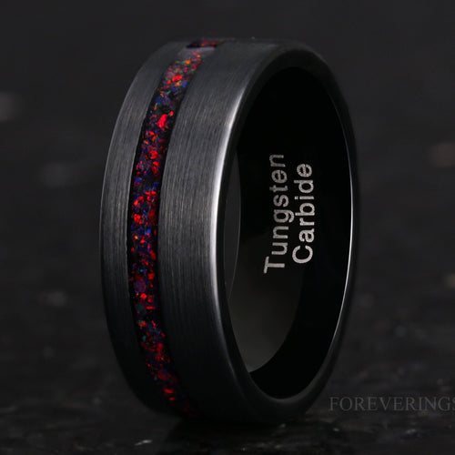 Men's 8mm brushed black tungsten ring with a black fire opal stripe, angled close-up