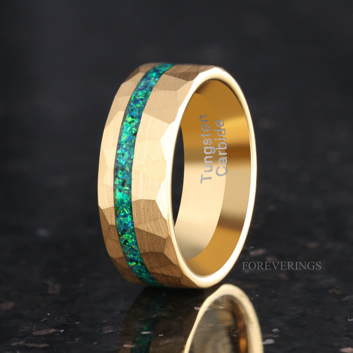 Men's 8mm hammered gold tungsten ring with a green emerald fire opal stripe, angled view
