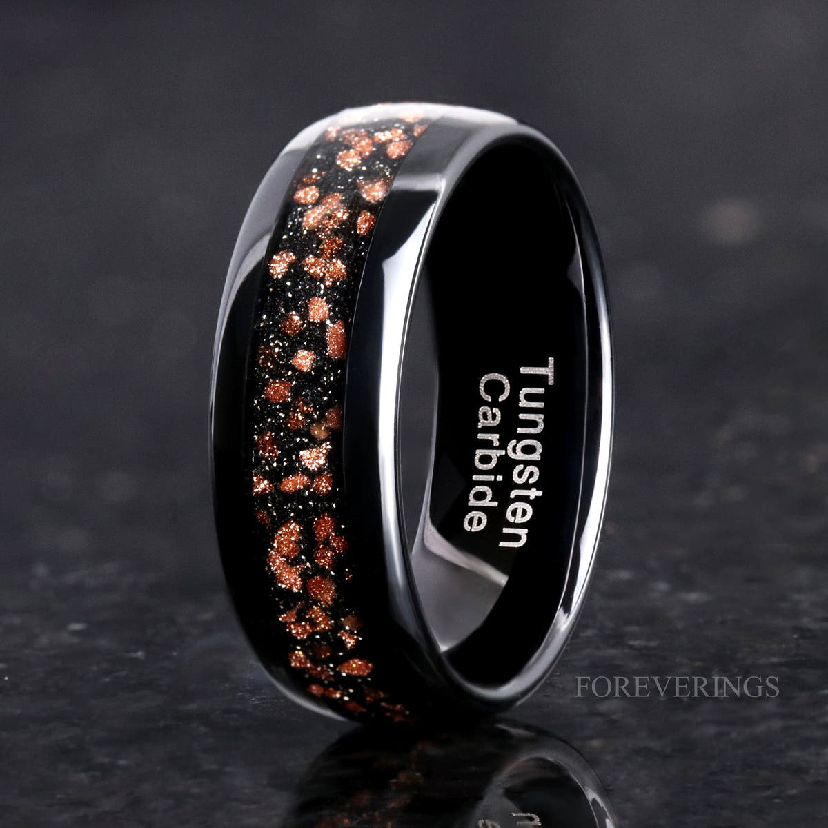His 8mm black tungsten ring with red goldstone inlay, angled to show the interior