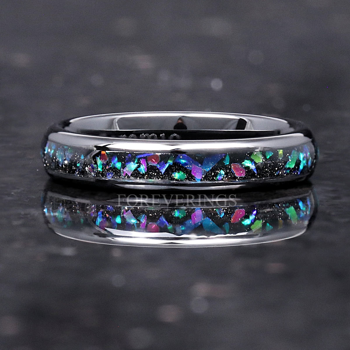 Women's 4mm black ceramic ring with galaxy opal inlay lying flat, front view